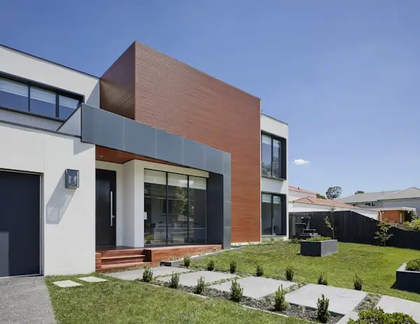Modern two-story home with geometric facade and landscaped front yard