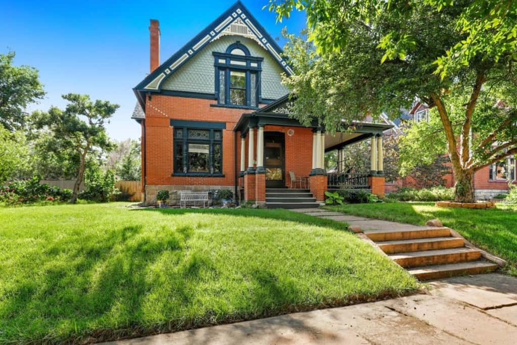 Two-story residential home with front porch and landscaped yard