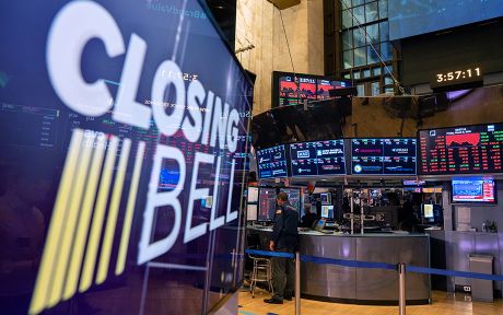 New York Stock Exchange trading floor with closing bell display and market screens