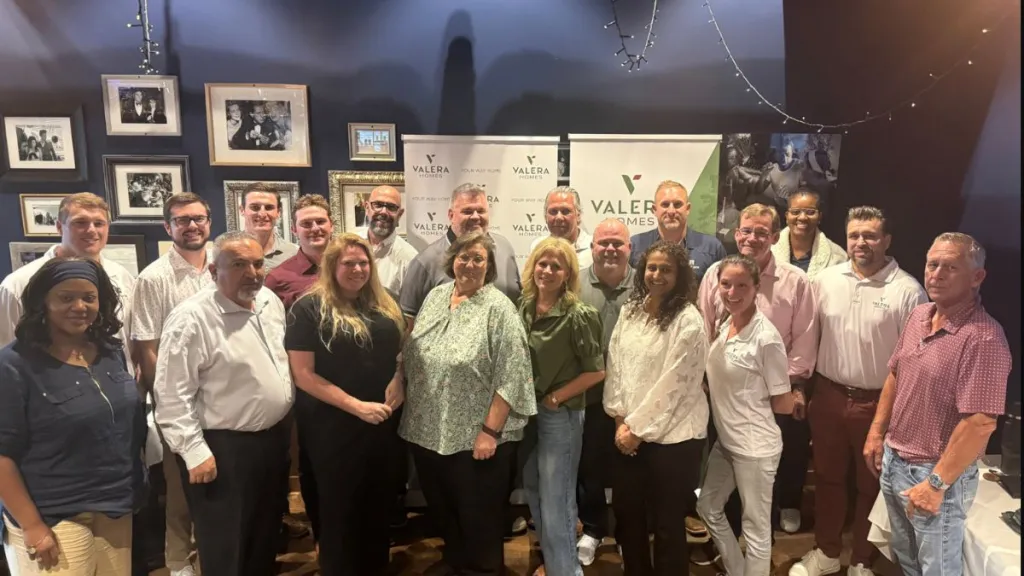 Valera Homes team posing together at an indoor company event