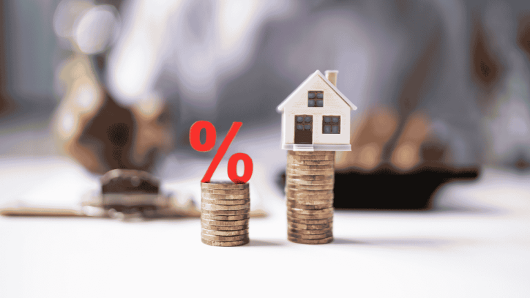 House model atop stacked coins beside a red interest rate symbol