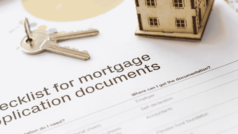 Mortgage application document checklist beside house keys and model home